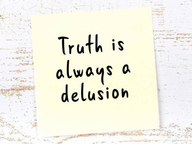 Tahta duvarda el yazısı motivasyon alıntısı olan sarı yapışkan not