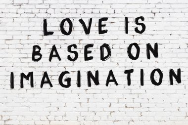 Beyaz tuğla duvar ve bilgece alıntıların yazılı olduğu siyah yazı.