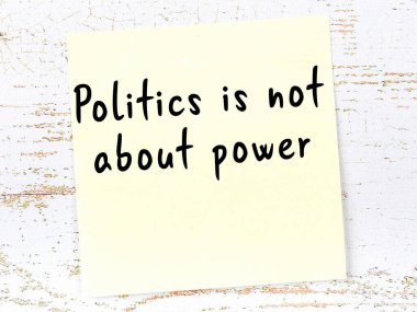 Sarı yapışkan not, ahşap duvarda el yazısıyla yazılmış zekice bir alıntıyla.