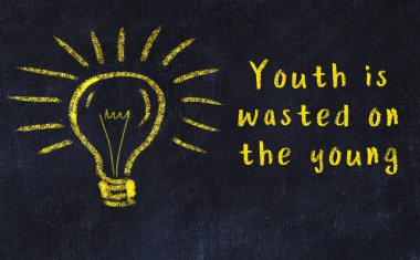 Bilgece bir alıntı ve siyah karatahtaya bir ampul çizimi