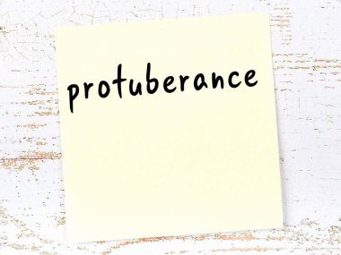 Tahta duvarda el yazısıyla yazılmış sarı yapışkan bir not var.