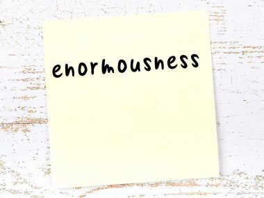 Tahta duvardaki sarı yapışkan notta el yazısıyla yazılmış muazzamlık var.