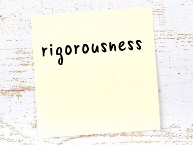 Tahta duvardaki sarı yapışkan notta elle yazılmış titizlik var.