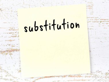 Yerine koyma konusunda hatırlatma kavramı. Tahta duvarda üzerinde yazı olan sarı yapışkan kağıt.