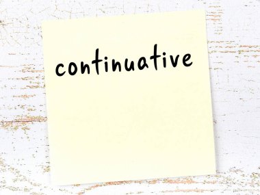 Devamlılığı hatırlatma kavramı. Tahta duvarda üzerinde yazı olan sarı yapışkan kağıt.
