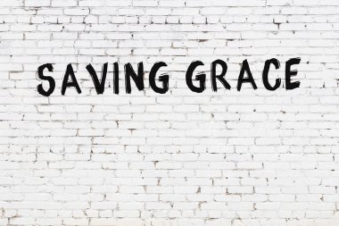 Üzerinde yazı olan beyaz tuğla duvar siyah boyayla el yazısıyla kaydediliyor.