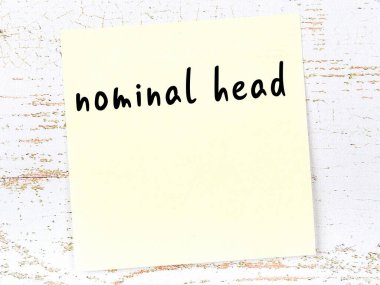 Nominal kafa hakkında hatırlatma kavramı. Tahta duvarda üzerinde yazı olan sarı yapışkan kağıt.