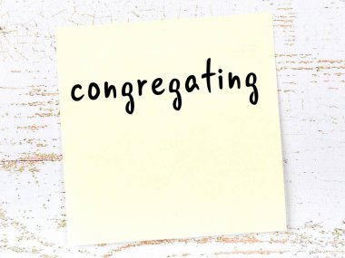 Toplanmayla ilgili hatırlatma kavramı. Tahta duvarda üzerinde yazı olan sarı yapışkan kağıt.