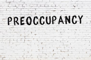 Yazı meşguliyeti beyaz tuğla duvara siyah boya ile yazılmış..