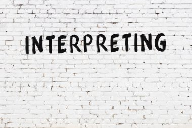 Üzerinde yazı olan beyaz tuğla duvar. Siyah boyayla yazılmış.