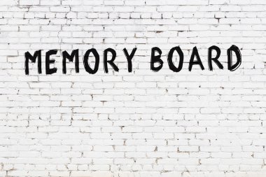 Üzerinde siyah boya olan beyaz tuğla bir duvar.