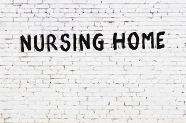 Beyaz tuğla duvara siyah boya ile yazılmış bir bakım evi..