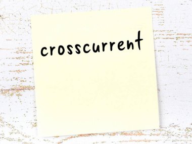 Tahta duvarda, el yazısıyla yazılmış çapraz yazı olan sarı yapışkan bir not.