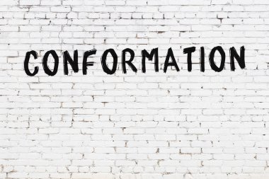 Beyaz tuğla duvara siyah boya ile yazılmış bir yazı..