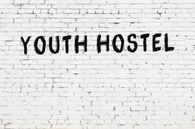 Beyaz tuğla duvarda siyah boyayla yazılmış bir pansiyon..