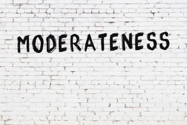 Beyaz tuğla duvara siyah boya ile yazılmış ılımlılık..