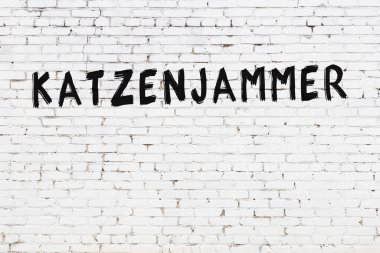 Yazı Katzenjammer, beyaz tuğla duvara siyah boya ile yazılmış..