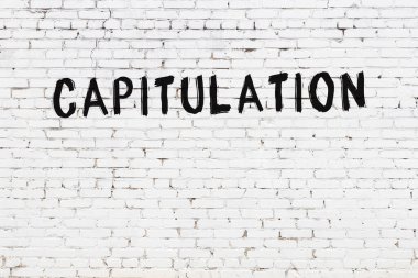 Beyaz tuğla duvara siyah boya ile yazılmış bir yazı..