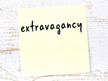 Savurganlık hakkında hatırlatma kavramı. Tahta duvarda üzerinde yazı olan sarı yapışkan kağıt.