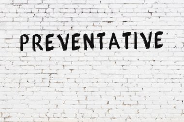 Siyah boyalı, el yazısıyla önleyici yazısıyla beyaz tuğla duvar.