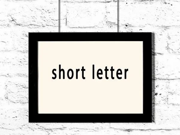 Black Wooden Frame Inscription Short Letter Hanging White Brick Wall — Stock Photo, Image