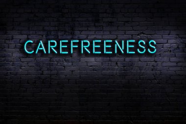 Tuğla duvara karşı dikkatli yazıtlı neon tabela. Gece görünümü