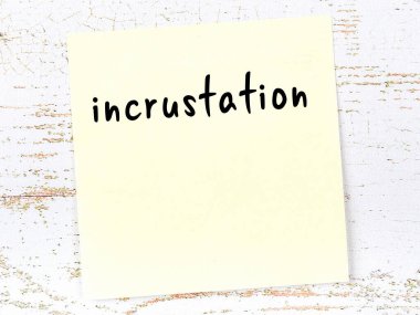 Tahta duvarda el yazısıyla yazılmış sarı yapışkan bir not var.