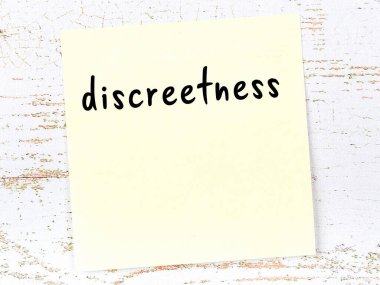 Tahta duvardaki sarı yapışkan notta el yazısıyla yazılmış ketum yazılar var.