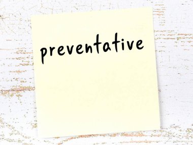 Tahta duvardaki sarı yapışkan notta el yazısı önleyici madde var.