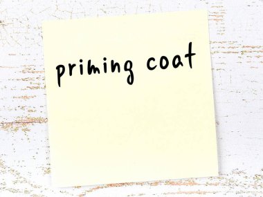 Palto asma konusunda hatırlatma kavramı. Tahta duvarda üzerinde yazı olan sarı yapışkan kağıt.