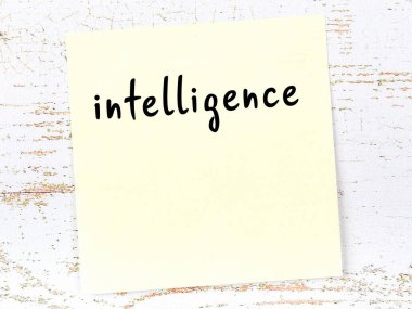 Tahta duvardaki sarı yapışkan notta el yazısıyla yazılmış zeka var.