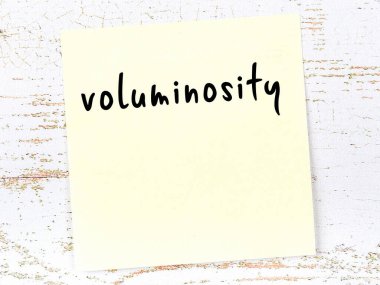 Tahta duvarda el yazısıyla yazılmış sarı yapışkan bir not.