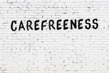 Beyaz tuğla duvara siyah boya ile yazılmış yazıtlar..