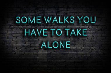 Tuğla duvardaki ışıklı neon tabela olarak bilgece alıntı