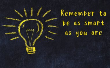 Bilgece bir alıntı ve siyah karatahtaya bir ampul çizimi