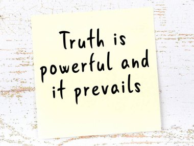 Tahta duvarda el yazısı motivasyon alıntısı olan sarı yapışkan not