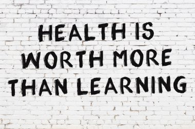 Üzerinde mantıklı alıntıların yazılı olduğu siyah boyanmış beyaz tuğla duvar.