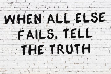 Beyaz tuğla duvar ve bilgece alıntıların yazılı olduğu siyah yazı.