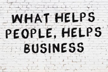 Beyaz tuğla duvar ve bilgece alıntıların yazılı olduğu siyah yazı.