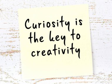 Sarı yapışkan not, ahşap duvarda el yazısıyla yazılmış zekice bir alıntıyla.