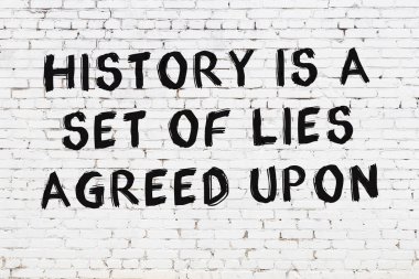 Beyaz tuğla duvar ve bilgece alıntıların yazılı olduğu siyah yazı.