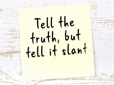 Sarı yapışkan not, ahşap duvarda el yazısıyla yazılmış zekice bir alıntıyla.