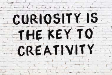 Üzerinde mantıklı alıntıların yazılı olduğu siyah boyanmış beyaz tuğla duvar.