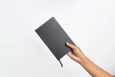 Beyaz arka planda sade siyah kapaklı bir kitabı tutan bir el. Boş kitap kapağı. Bir adamın eli kitap tutuyor..