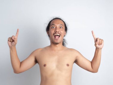 İki eli de şişkin gözlerle ve gülümseyen ağızla gösteren Asyalı bir adam beyaz izole arka planda giysileri olmadan..