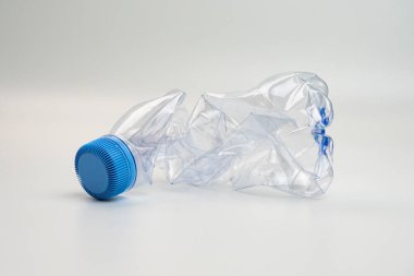 One crumpled plastic bottle isolated on white. Environmental conservation concept by not using plastic bottles. Environmental care movement from plastic waste.