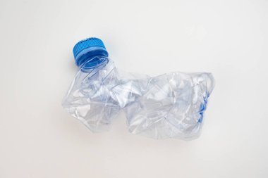 One crumpled plastic bottle isolated on white. Environmental conservation concept by not using plastic bottles. Environmental care movement from plastic waste.