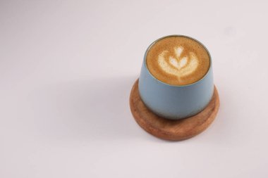 Üzerinde rosetta yaprağı latte sanat tasarımı, koyu espresso üzerine detaylı süt köpüğü deseni seramik bir fincanda latte sanatıyla yakın plan bir cappuccino fotoğrafı..
