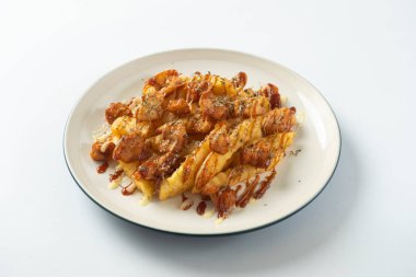 Çıtır Tavuk Doldurulmuş Patates, üstüne kremalı mayonez ve baharatlı sosla doldurulmuş tavuk, beyaz tabakta atıştırmak için mükemmel bir konforlu yemek tabağı yaratıyor..