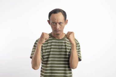 Saldırgan Asyalı adam kameraya karşı dövüşmeye çalışıyor, yumruğunu sallıyor, ifadeyle boks yapıyor, cezalandırıyor, tehdit ediyor, taciz ediyor, öfkeden kuduruyor. Beyaz stüdyo geçmişinde izole edilmiş yakışıklı adam.